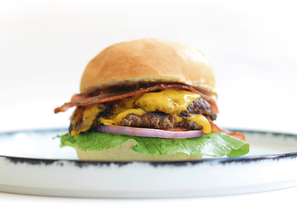 Hamburguesa Doble Smash Dos carnes crocantes por fuera y jugosas por dentro, con cheddar derretido, tocineta crispy y pan suave tostado.