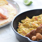 Cacerola Campesina con chicharrón, huevos pericos y chorizos, junto a Huevos Estrellados con jamón serrano y papas rústicas.